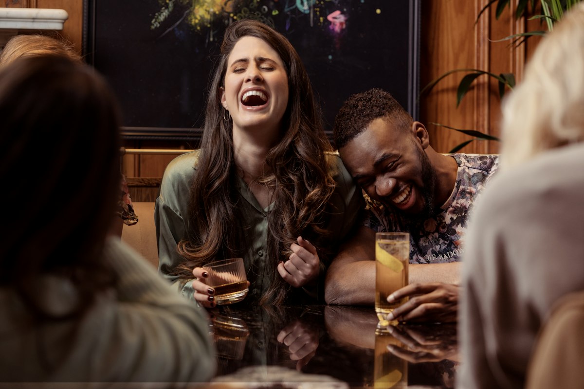 Friends laughing hard around a table
